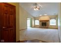 Cozy living room featuring a classic brick fireplace, neutral carpeting, and abundant natural light at 413 Blue Spring Dr, Indianapolis, IN 46239