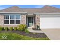 Charming brick home with a well-manicured lawn and attached two car garage at 4420 Wild Turkey Dr, Indianapolis, IN 46239