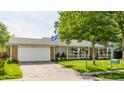 Inviting one-story home with a garage, large front yard, and a covered porch with white railings at 48 Wilson Dr, Carmel, IN 46032