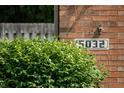 Close-up of the house number '5032' displayed on a brick wall next to a green bush at 5032 Monticello Dr, Columbus, IN 47203