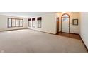 Spacious living room with neutral carpet, multiple windows, and a view of the front door at 5032 Monticello Dr, Columbus, IN 47203