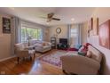 Bright living room with hardwood floors, a ceiling fan, and ample natural light from a large window at 5609 Meadowood Dr, Indianapolis, IN 46224