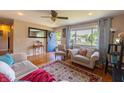 Cozy living room with hardwood floors, a large window, and comfortable seating area with a ceiling fan at 5609 Meadowood Dr, Indianapolis, IN 46224