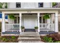 Inviting front porch with swing, lush ferns, and classic architectural details at 5919 Central Ave, Indianapolis, IN 46220