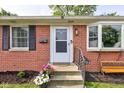 A welcoming front porch with potted flowers and a cozy bench seat at 5923 W 29Th Pl, Indianapolis, IN 46224