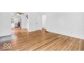 Neutral room with hardwood floors and white walls leading into kitchen area at 6235 N Temple Ave, Indianapolis, IN 46220