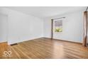 Bright room with hardwood floors, white walls, large window, and neutral finishes at 6235 N Temple Ave, Indianapolis, IN 46220