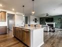 Open concept kitchen island with stainless steel dishwasher, and seating opening up into the living room at 628 Tess Blvd, Westfield, IN 46074