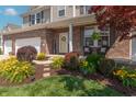 Inviting home entrance with colorful landscaping, a 'Welcome' sign, and comfortable seating at 6480 E Coal Bluff Ct, Camby, IN 46113
