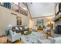 Inviting living room featuring vaulted ceilings, hardwood floors, a cozy fireplace, and ample natural light at 6975 Milhouse Rd, Indianapolis, IN 46221