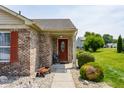 Welcoming covered front entry with a decorative red door and landscaped surroundings at 7 Pondview Ct, Brownsburg, IN 46112