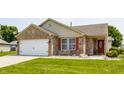 Inviting brick home with a two-car garage, red door, and lush green lawn at 7 Pondview Ct, Brownsburg, IN 46112