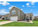 Rear exterior of home featuring a two-car garage and outdoor seating area for relaxation at 7252 Lockford N, Avon, IN 46123