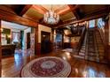 A grand foyer with wood detailing, a chandelier, and a sweeping staircase at 825 E Washington St, Muncie, IN 47305