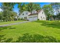 A beautiful home with lush green lawn, mature trees and a long driveway leading to the attached garage at 8435 Hilltop Ln, Martinsville, IN 46151