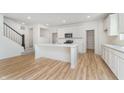 Bright open-concept kitchen with white cabinets, stainless appliances, and large center island at 876 Cowley Dr, Westfield, IN 46074