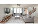 Spacious living room featuring modern sofas, decorative rug, and staircase with wood railing at 9248 Hawley Dr, Indianapolis, IN 46216