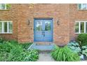 Inviting brick entryway with double blue doors, decorative plants, and stylish outdoor lighting at 9256 Colgate St, Indianapolis, IN 46268