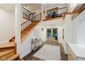 Grand two-story foyer featuring a staircase with wooden treads, a balcony, and double glass front doors at 1065 E 76Th St, Indianapolis, IN 46240