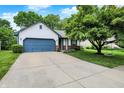 Charming single Gathering home featuring an attached garage, long driveway, and mature trees at 11518 Cherry Blossom W Dr, Fishers, IN 46038