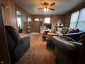 Spacious living room with wood paneling, a ceiling fan, and comfortable furnishings at 1206 Lincoln St, Shelbyville, IN 46176