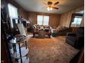 Cozy living room featuring wood paneling, carpet, and a ceiling fan at 1206 Lincoln St, Shelbyville, IN 46176