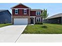 Charming two-story home boasting well-maintained landscaping and an inviting two-car garage at 1351 Byron St, Greenfield, IN 46140