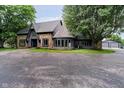 Charming home with a stone and wood exterior, complemented by a circular window and well-manicured lawn at 16714 Oak Rd, Westfield, IN 46074