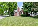 Traditional style home featuring brick and stone accents, lush lawn and mature shade trees at 1702 Kessler Blvd E Dr, Indianapolis, IN 46220