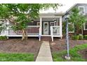 Charming front porch with white railing and decorative hanging flower baskets provides cozy curb appeal at 1702 Kessler Blvd E Dr, Indianapolis, IN 46220