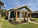 Inviting home with a welcoming porch and meticulously arranged flower beds at 1818 Broadway St, Anderson, IN 46012