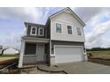 Inviting two-story home with a covered entry, gray siding, white trim, and a two-car garage at 1890 Victor Higgins Dr, Shelbyville, IN 46176