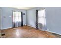 Well-lit living room featuring hardwood floors and windows dressed with patterned curtains at 1904 N Bosart Ave, Indianapolis, IN 46218