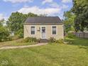 Cozy single-story home featuring a manicured lawn, sidewalk and mature trees at 2018 N Rochester Ave, Indianapolis, IN 46222