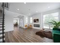 Bright, open living room with modern fireplace, hardwood floors, and staircase at 205 Poplar St, Westfield, IN 46074