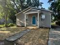Home with gray siding, covered porch, and stone walkway leading to a bright blue front door at 2127 Haines Ave, Indianapolis, IN 46221