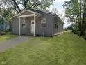 Beautiful home exterior featuring gray siding, a covered porch, and lush green lawn at 2127 Haines Ave, Indianapolis, IN 46221