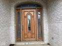 Elegant wood front door with decorative glass and brick surround at 4230 Raintree Blvd, Greenwood, IN 46143
