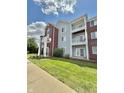 Multi-story condo building with balconies, red brick accents, and a lush green lawn at 5019 Amber Creek Pl, Indianapolis, IN 46237