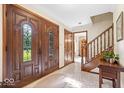 Elegant foyer with hardwood floors, decorative glass doors, and staircase at 54 Horseshoe Ln, Carmel, IN 46033
