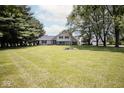 Two-story home with a lush green lawn, mature trees, and an American flag at 5707 In-234, McCordsville, IN 46055