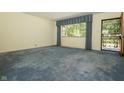 Spacious living room with cozy blue carpet and ample natural light at 5927 Meadowood Dr, Speedway, IN 46224
