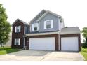 Beautiful home showcasing a brick and vinyl exterior, a two-car garage, and a neat front yard at 6563 Enclave Blvd, Greenwood, IN 46143