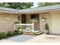 Inviting front porch with decorative plants, a patterned rug, and stylish stone accents at 7150 Combs Rd, Indianapolis, IN 46237
