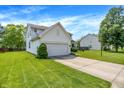 Side view of a two-story home with an attached garage, driveway, and a green lawn at 7337 Wythe Dr, Noblesville, IN 46062
