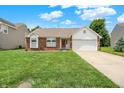 Charming single Gathering home with brick facade, two-car garage and well-manicured lawn on a sunny day at 8038 Sydney Ln, Avon, IN 46123