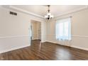 Dining area with wood flooring, a modern chandelier, and a bright window with sheer curtains at 8117 Scarborough Ct, Indianapolis, IN 46256