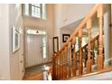 The foyer features hardwood floors, an open staircase, and a decorative stained-glass window above the front door at 8460 Brittany N Ct, Indianapolis, IN 46236