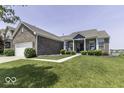 Beautiful brick home featuring a meticulously maintained lawn, inviting front porch, and ample parking space at 8864 S Tibbs Ave, Indianapolis, IN 46217