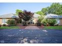 Stunning single-story brick home featuring manicured landscaping and a paved walkway leading to the entrance at 9420 N Kenwood Ave, Indianapolis, IN 46260